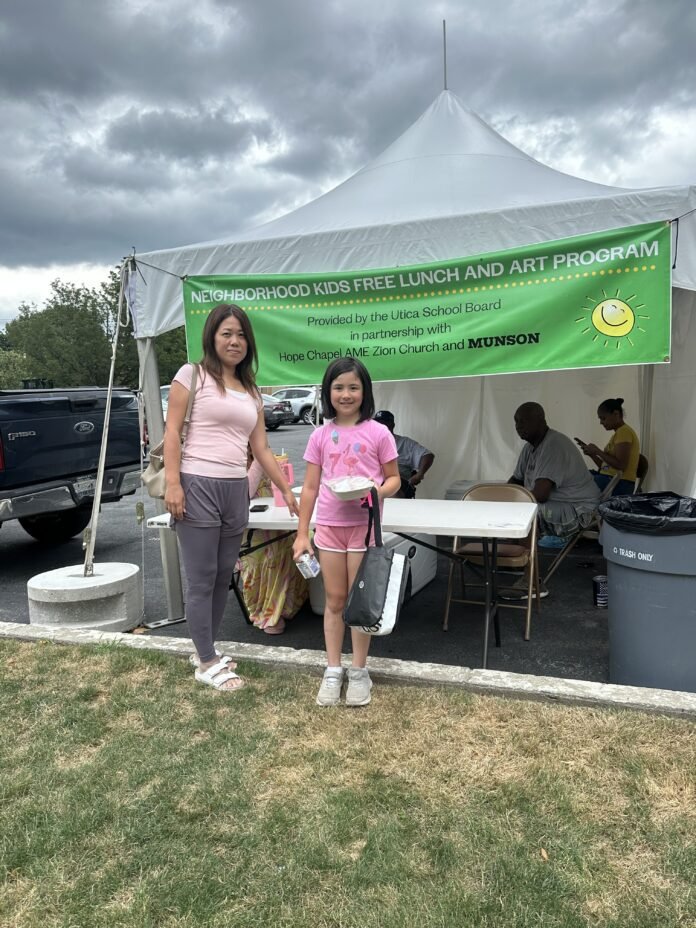 A mother and her daughter pick up a free summer lunch meal at Munson on Thursday, July 17, 2025